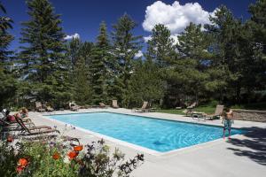 een vrouw staat bij een zwembad bij Red Pine Condos Unit #A7 in Park West Ski Area Heliport