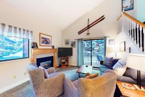 een woonkamer met twee stoelen en een open haard bij Red Pine Condos Unit #A7 in Park West Ski Area Heliport