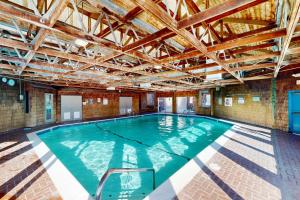 a large indoor swimming pool with a wooden ceiling at Newport Sunshine #C208 in Newport
