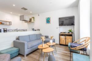 a living room with a couch and two tables at Gîte Honorus - SPA - Puy duFou - Grande capacité in Les Épesses