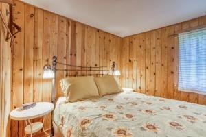 Schlafzimmer mit Holzwänden, einem Bett und einem Tisch in der Unterkunft Hidden Villa Cottage #5 - The Sunflower Cottage in Cannon Beach