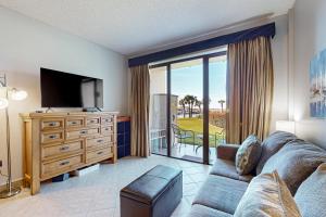 a living room with a couch and a television at Pirates Bay A106 in Fort Walton Beach