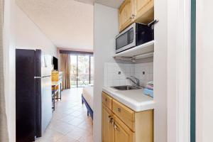 a kitchen with a sink and a black refrigerator at Pirates Bay A106 in Fort Walton Beach