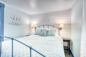 a bedroom with a metal bed with blue pillows at Hidden Villa Cottage #4 - The Ocean Cottage in Cannon Beach