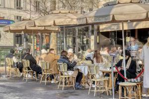 un gruppo di persone seduti ai tavoli fuori da un bar di 120 m2 Luxury Eiffel Signature a Parigi