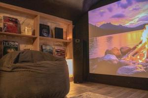 a room with a large screen in the corner of a room at La Villa Aliénor - Spa et Cinéroom in Montigny-Lencoup