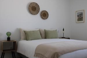 Un dormitorio con una gran cama blanca con dos almohadas. en Alto Mar Apartment 2, en Atouguia da Baleia