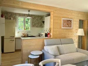 a living room with a couch and a kitchen at La villa Les Rosiers en Cévennes in Saint-Martial
