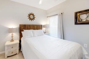 una camera da letto bianca con un letto bianco e una finestra di Tidewater 906 a Orange Beach Altre 17 foto