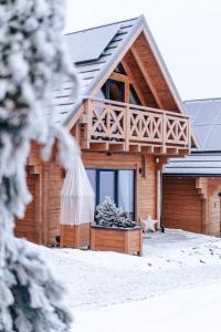 ein Blockhaus im Schnee mit Fenster in der Unterkunft Domki Osada Zieleniec in Duszniki-Zdrój