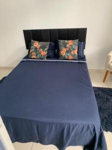 a blue bed with two pillows on top of it at Pertinho do mar para relaxar in Água Boa +3 photos