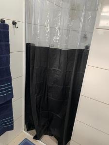 a shower with a black shower curtain in a bathroom at Pertinho do mar para relaxar in Água Boa