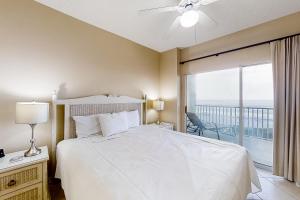 Un dormitorio con una cama blanca y un balcón. en Tidewater 608, en Orange Beach 21 fotos más