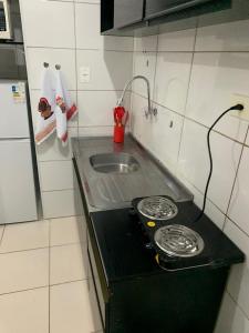 a kitchen counter with a stove and a sink at Pertinho do mar para relaxar in Água Boa