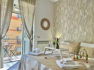 a bedroom with a bed with towels and a table at Mazzocchi House welcome wine in Naples