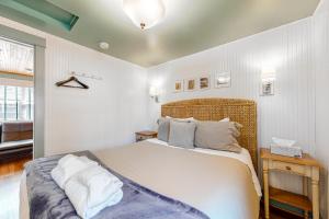 une chambre avec un grand lit avec des draps et des oreillers blancs dans l'établissement Hidden Villa Cottage #3 - The Garden Cottage, à Cannon Beach