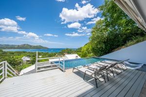 an outdoor deck with chairs and a swimming pool at Villa Vista Bahia in Coco