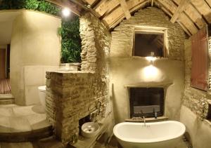 ein Steinbad mit einem Waschbecken und einem Kamin in der Unterkunft The Lodge Rooms in Coleford