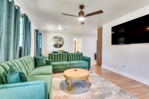 a living room with green couches and a table at 12 Mi to BOK Center Pet-Friendly Home with Yard! in Union