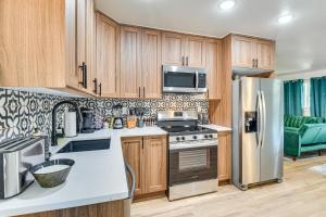 a kitchen with wooden cabinets and a stainless steel refrigerator at 12 Mi to BOK Center Pet-Friendly Home with Yard! in Union