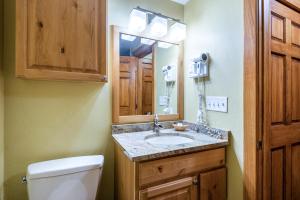 Un baño con lavabo, inodoro y espejo. en Mountain Village Studio #225, en Park City