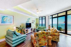 a living room with a couch and chairs and a television at Phoenix West 502 in Romar Beach