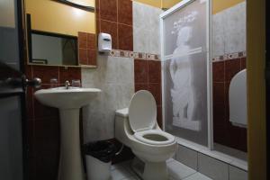 y baño con aseo y lavamanos. en Hotel Coca Imperial, en Puerto Francisco de Orellana
