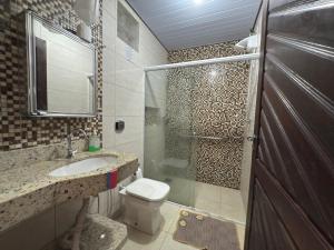a bathroom with a toilet and a sink and a shower at Apartamento com 2 quartos, 2 banheiros e Garagem em sinop in Sinop +1 photo