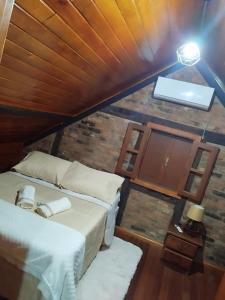 a bedroom with a bed and a brick wall at Recanto Nascer do Sol in Nova Petrópolis