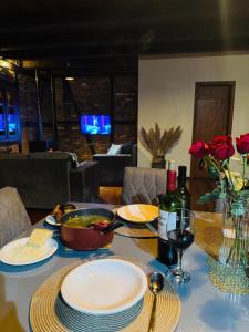 a table with plates of food and a glass of wine at Recanto Nascer do Sol in Nova Petrópolis +41 photos