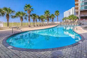 Una gran piscina con palmeras en un complejo turístico. en Tidewater 908, en Orange Beach