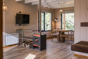 a living room with a fireplace and a tv at 4Puntas Lodge in Lago Meliquina