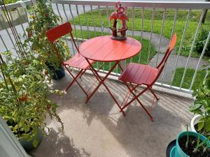 einen roten Tisch und zwei Stühle auf einer Veranda in der Unterkunft Boho Retreat 3BD Condo Close to Ottawa in Gatineau