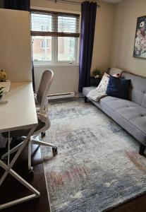 ein Wohnzimmer mit Couch und Schreibtisch in der Unterkunft Boho Retreat 3BD Condo Close to Ottawa in Gatineau + 3 Fotos