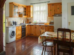 a kitchen with a table and a washing machine at Holiday home with fireplace and private garden in Grąbczyn +21 photos