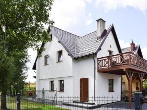 a house with a balcony on top of it at Holiday Home in Kashubia with Pool & Sauna in Częstkowo