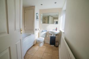 a bathroom with a sink and a tub and a toilet at The Sovereign in Whitstable +41 photos
