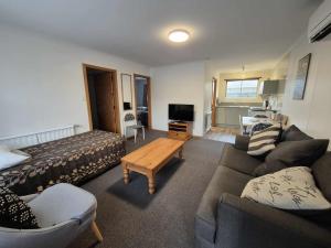 a living room with a couch and a table at Alexandra Motor Lodge NZ in Alexandra