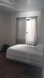 a bed in a room with a window at Casa 3 quartos in Pontal do Paraná