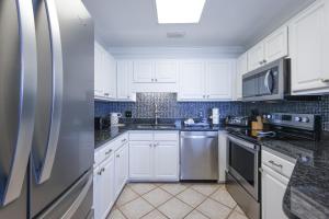 a white kitchen with white cabinets and appliances at Phoenix VI 61507 in Orange Beach