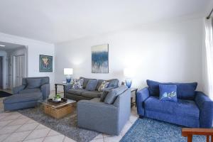 a living room with two blue couches and a table at Phoenix VI 61507 in Orange Beach
