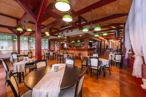 a restaurant with tables and chairs and a bar at Bobrowy Resort in Bobrowa
