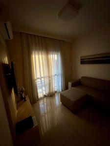 a living room with a couch and a window at Apto 601 Hotel Mont Blanc Premium in Ribeirão Preto