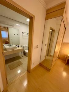 a bathroom with a sink and a toilet and a mirror at Apto 601 Hotel Mont Blanc Premium in Ribeirão Preto