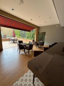 a large room with tables and chairs and a patio at Apto 601 Hotel Mont Blanc Premium in Ribeirão Preto