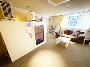 a living room with a tv and a couch at トロピカーナ in Fukuyama