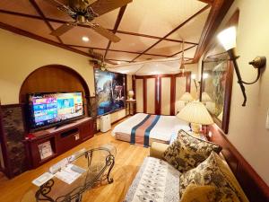 a hotel room with a bed and a tv at トロピカーナ in Fukuyama