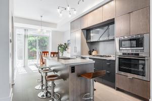 kuchnia ze sprzętem ze stali nierdzewnej oraz bar z stołkami w obiekcie Luxury Properties close to Rogers Center in Toronto Downtown Core w mieście Toronto