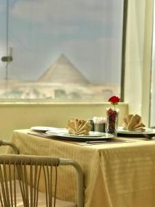 a table with plates and napkins on top of it at Pyramids INN View in Cairo +63 photos