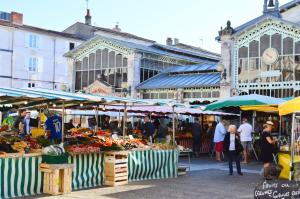 un groupe de personnes se promenant dans un marché de fruits et légumes dans l'établissement Nid du marché hypercentre La Rochelle, wifi, à La Rochelle